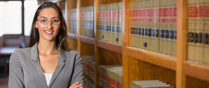 female student standing in a law library