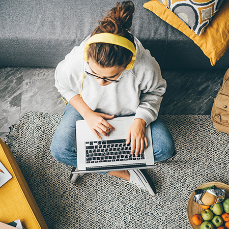 Student in dorm room using laptop