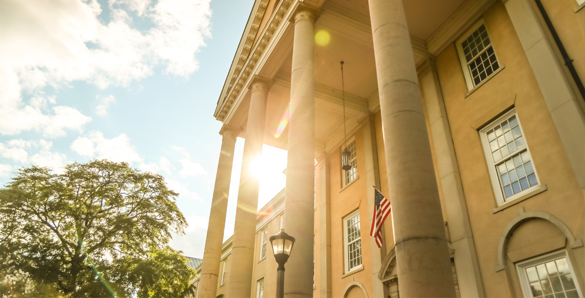 Rising high above the stately columns of Preston Residential College, the sun highlights the front entrance way for this residence hall.