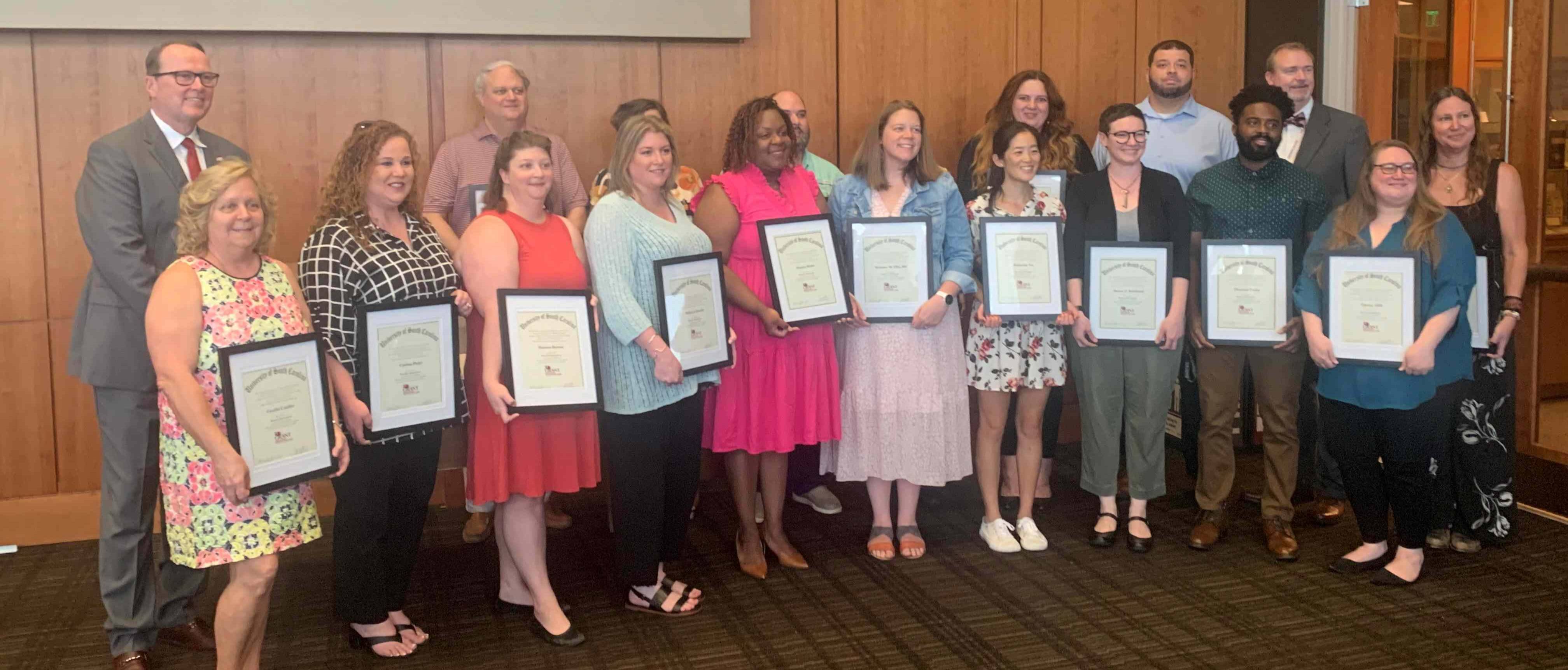 Research training program participants in a group photo holding their certificates of completion