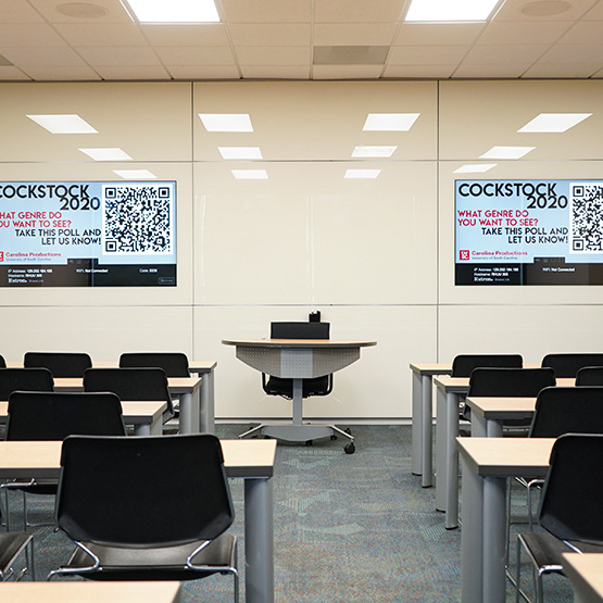 a view of the room with rows of chairs set up and a desk