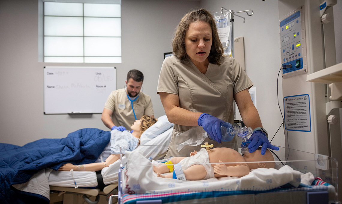 Nursing students work in the simulation lab.