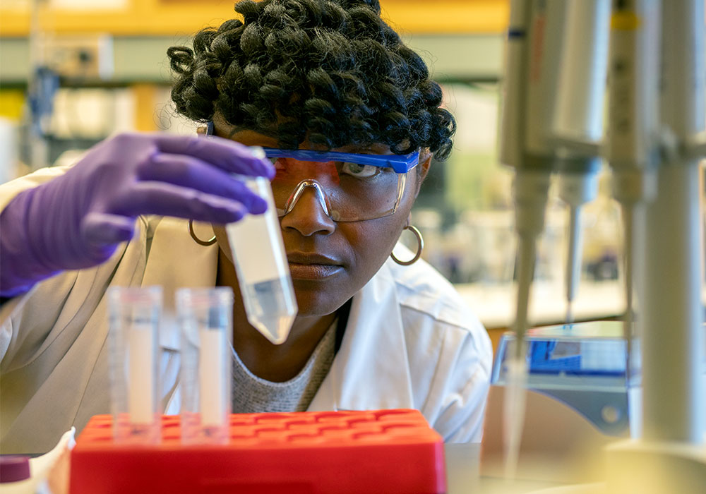 Researcher holding a test tube at eye level.