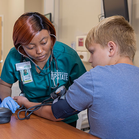 Nursing student taking the blood pressure of a child. 