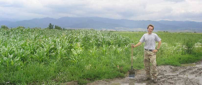 man in field with shovel