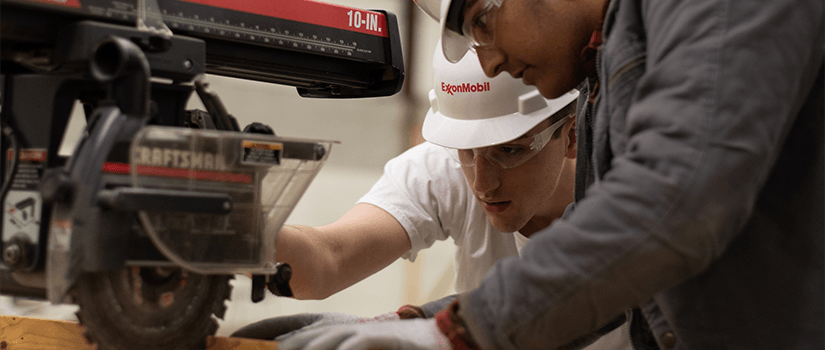 two students use a saw during tiger burn prep