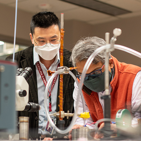 two researchers work with lab equipment