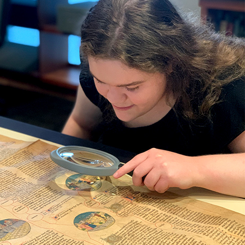 Hannah Martin looking at a document through a microscope.