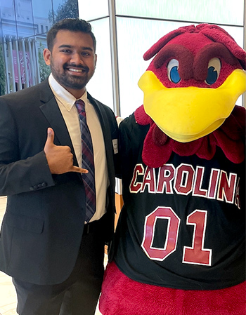 Tejas Patel posing with Cocky at Caroilna Day.